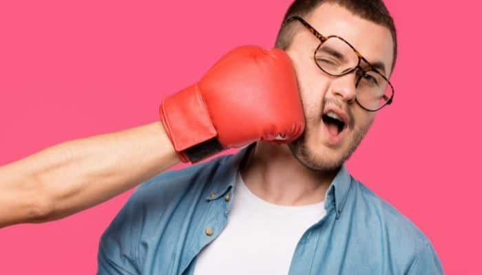 man in glasses being punched in the face