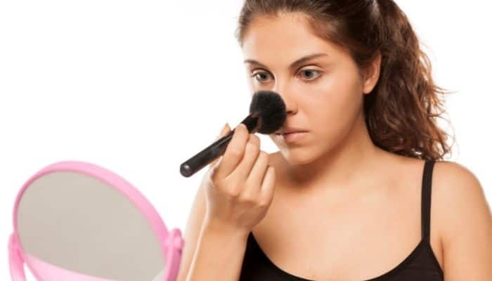 woman powdering nose with brush