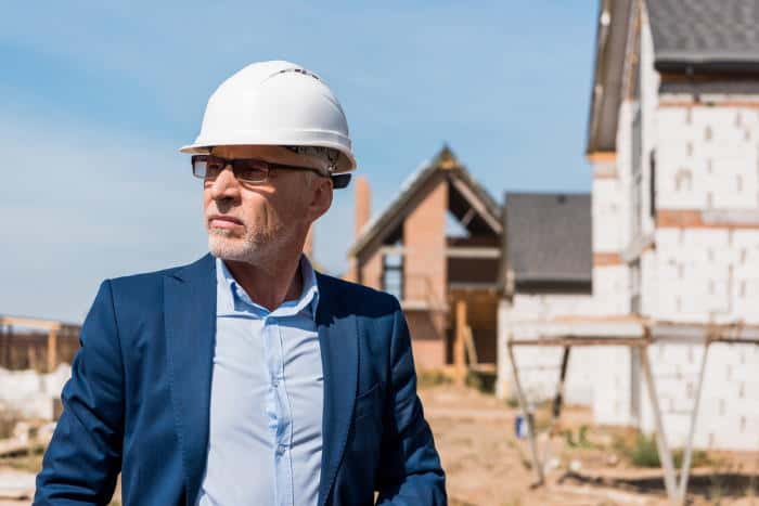 man in suit with glasses and construction helmet