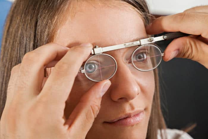 optician measuring woman's pupillary distance