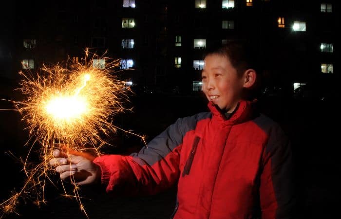 young boy holding sparkler