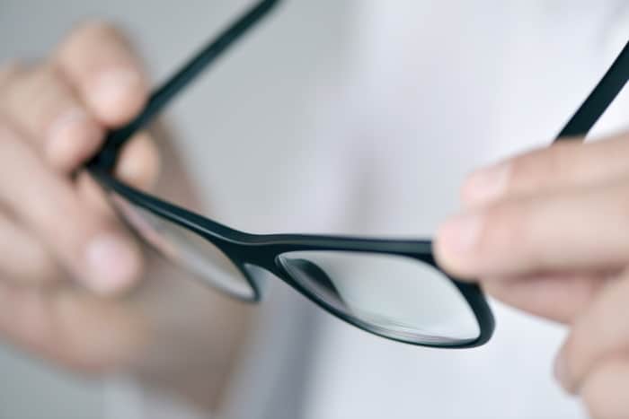 closeup of hands holding a pair of glasses