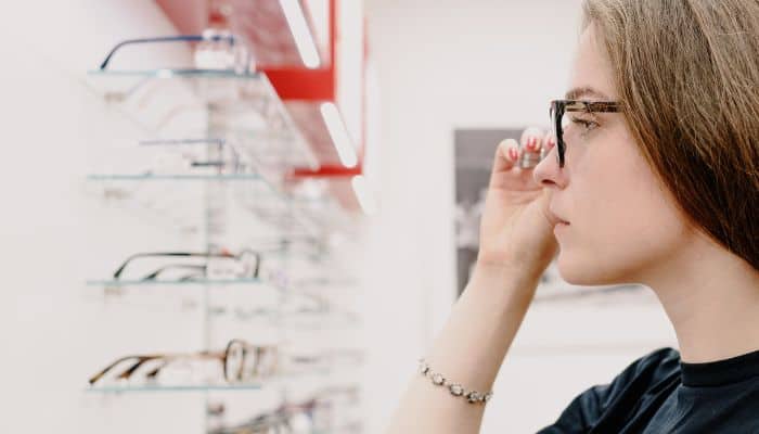 woman trying on glasses in optical
