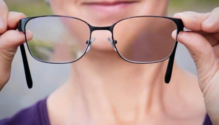 woman holding progressive glasses