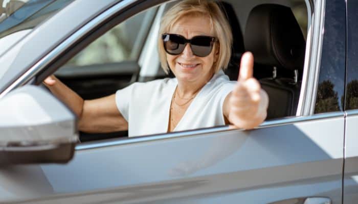 senior lady wearing sunglasses while driving