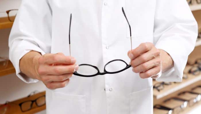 male optician holding glasses