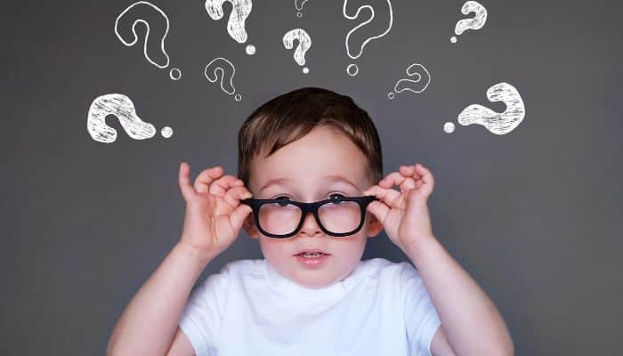 child wearing glasses with questions marks above head