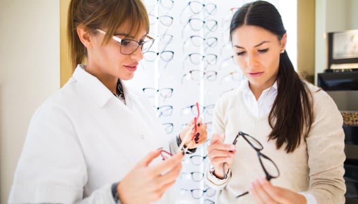 optician helping customer choose glasses