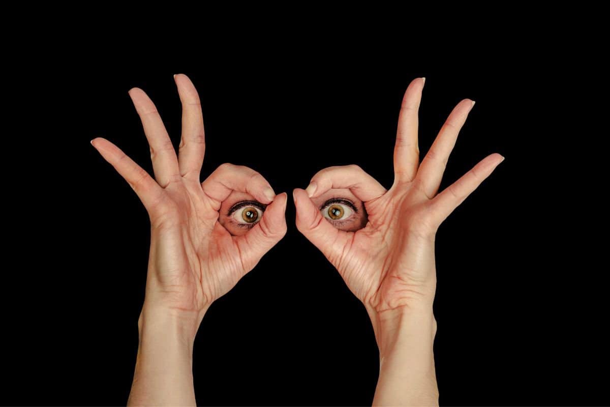 eyes looking through hand glasses