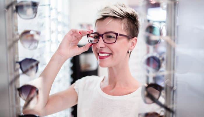 woman in optical shop trying on glasses