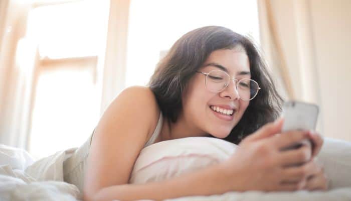 woman in glasses looking at smartphone 