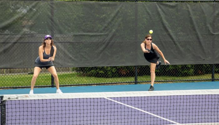 female pickleball partners playing