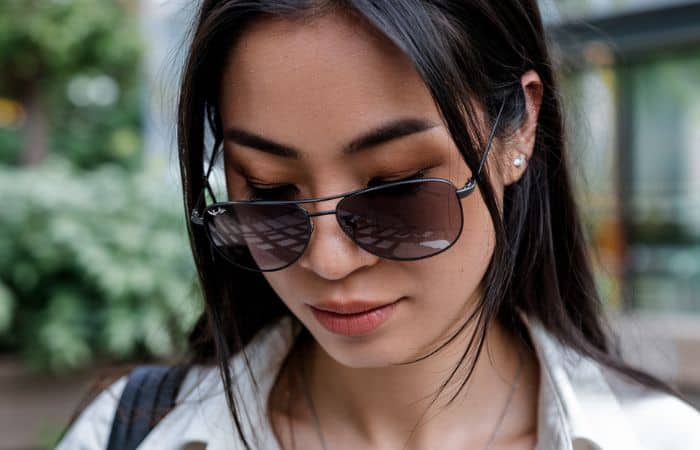 asian woman looking down with sunglasses sliding down her nose